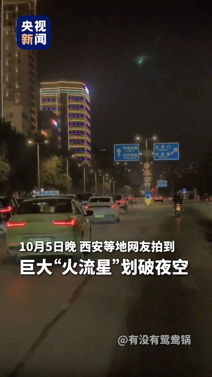 A nighttime city street scene with cars and illuminated buildings, featuring Chinese text that includes "巨大“火流星”划破夜空" and a "央视新闻" logo.