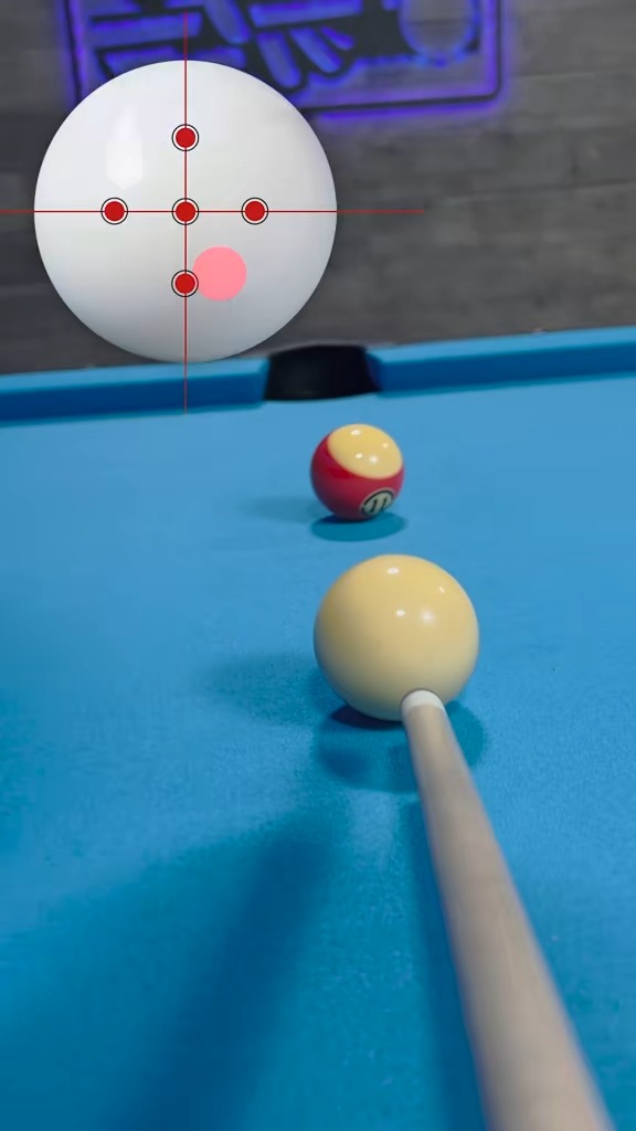 A billiards scene showing a cue ball with a targeting reticle overlay (red crosshairs and dot grid) and a ghost ball indicator, with a pool cue aimed at a yellow ball and a red-and-yellow striped 11-ball in the background.