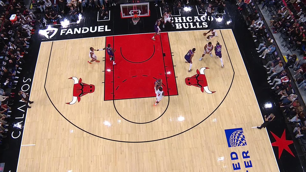 An overhead shot of a Chicago Bulls home game at the United Center shows #22, Caleb Wilson, executing a reverse layup near the basket during a contested play against the opposing team. The court displays prominent "Chicago Bulls," "FanDuel," and "United Center" logos, capturing the moment described in the accompanying post about Wilson's athletic finish.