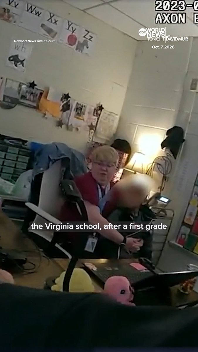 Body camera footage dated October 7, 2026, from "Newport News Circuit Court" shows a teacher in a first-grade Virginia classroom (decorated with alphabet posters) being comforted by another adult after being shot by a six-year-old student, with "ABC World News Tonight with David Muir" branding visible in the corner. The blurred figure in the foreground appears to be the injured teacher, illustrating the aftermath of the incident in which the child's mother later pleaded guilty to child neglect.