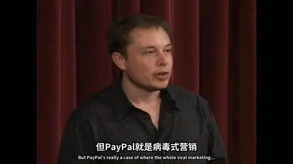 Elon Musk speaks in front of a red curtain with English subtitles 'But PayPal's really a case of where the whole viral marketing...' and Chinese subtitles '但PayPal就是病毒式营销' (But PayPal is viral marketing).