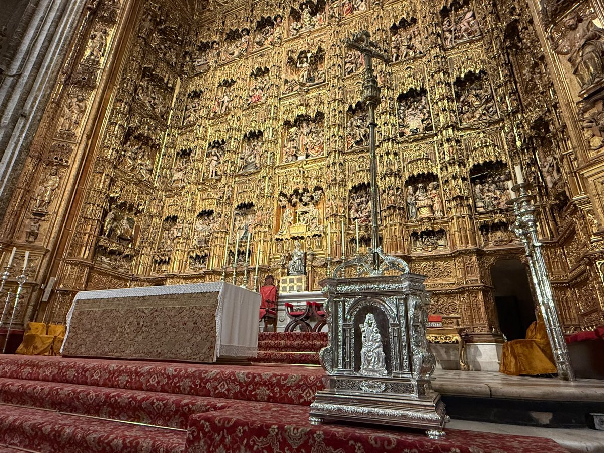 CatedraldeSev's tweet photo. La Catedral de Sevilla ha adquirido una nueva peana de plata para la Cruz Patriarcal de Francisco Merino, obra del siglo XVI situada en el Altar Mayor.

Realizada en plata de ley 930 por los talleres de Orfebrería Villarreal, bajo diseño propio y cincelada íntegramente a mano, la pieza toma como referencia obras de la orfebrería sevillana vinculadas a la Catedral, como la Custodia de Arfe, los relicarios de Francisco de Alfaro y la Puerta de San Fernando.

En sus cuatro caras aparecen Santa María de la Sede, el escudo del Cabildo, Santa Justa y Santa Rufina, y San Isidoro y San Leandro.

La nueva peana da continuidad a la tradición de la orfebrería al servicio del culto y contribuye a dignificar la disposición de la Cruz Patriarcal en el Altar Mayor.