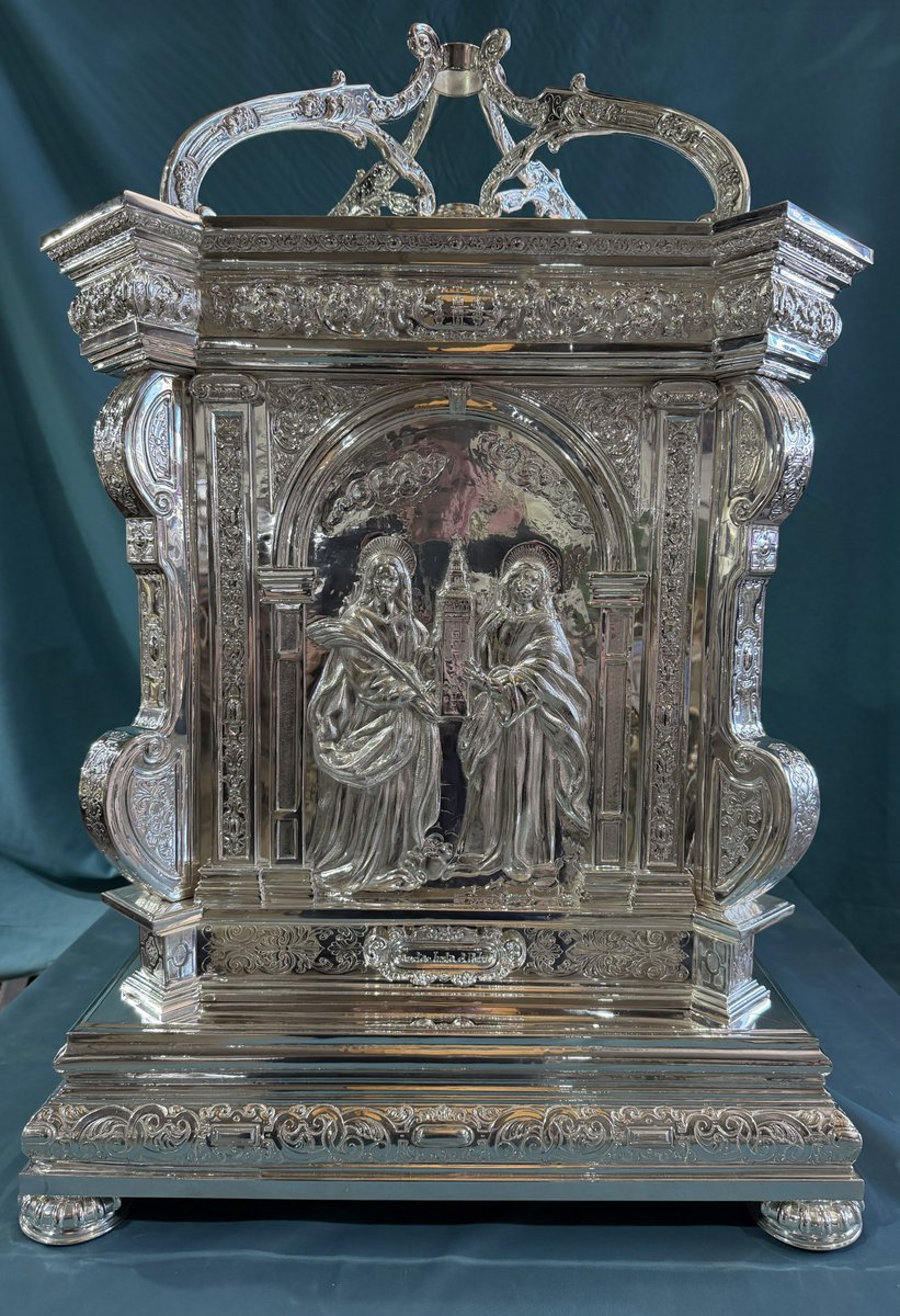 CatedraldeSev's tweet photo. La Catedral de Sevilla ha adquirido una nueva peana de plata para la Cruz Patriarcal de Francisco Merino, obra del siglo XVI situada en el Altar Mayor.

Realizada en plata de ley 930 por los talleres de Orfebrería Villarreal, bajo diseño propio y cincelada íntegramente a mano, la pieza toma como referencia obras de la orfebrería sevillana vinculadas a la Catedral, como la Custodia de Arfe, los relicarios de Francisco de Alfaro y la Puerta de San Fernando.

En sus cuatro caras aparecen Santa María de la Sede, el escudo del Cabildo, Santa Justa y Santa Rufina, y San Isidoro y San Leandro.

La nueva peana da continuidad a la tradición de la orfebrería al servicio del culto y contribuye a dignificar la disposición de la Cruz Patriarcal en el Altar Mayor.