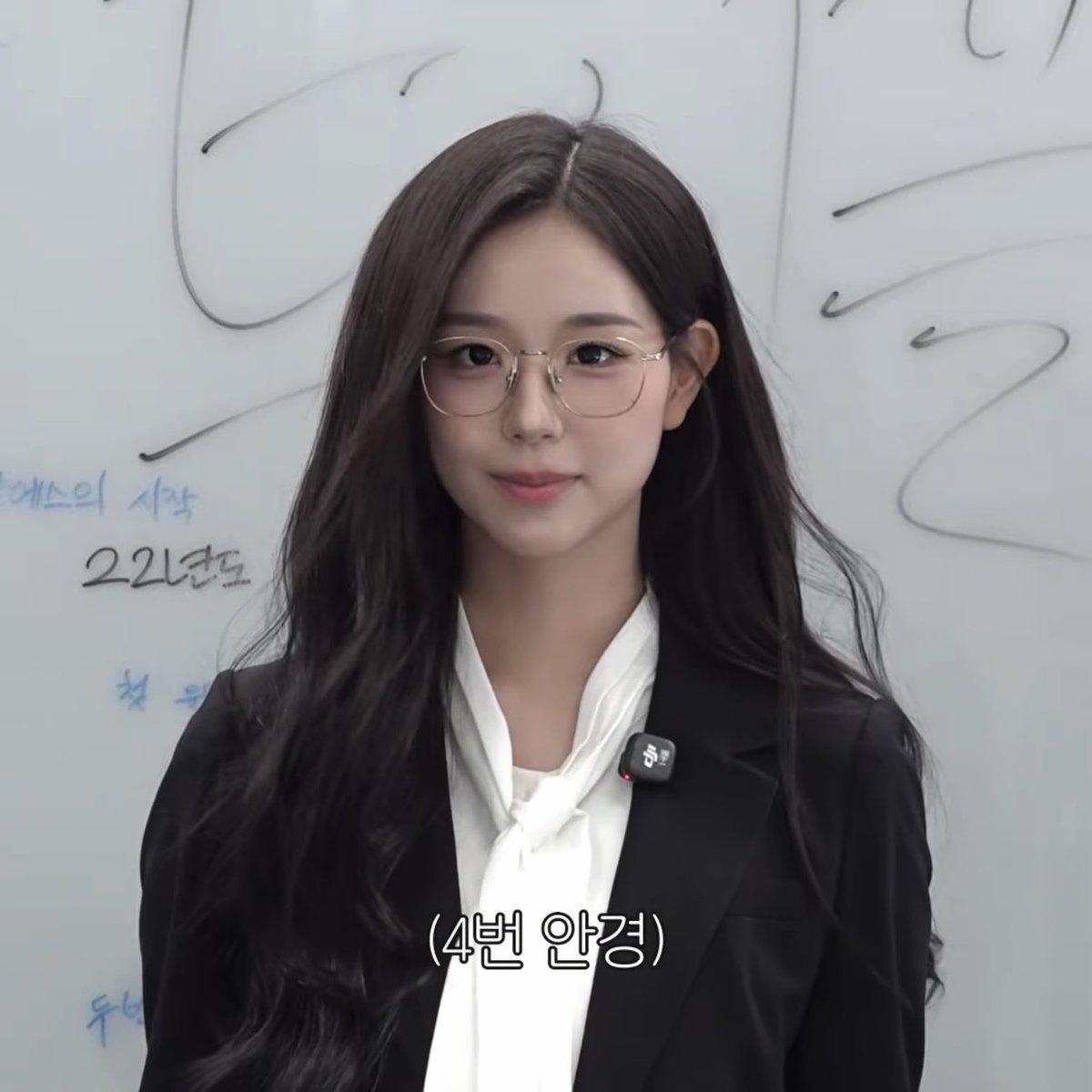 A young Korean woman with long dark hair and glasses wearing a black blazer and white blouse, with Korean text '(4번 안경)' meaning '(Glasses #4)' overlaid at the bottom.