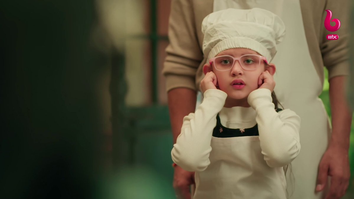 A young girl wearing a chef's hat, pink glasses, and an apron poses with her hands on her cheeks in an MBC-broadcast advertisement.
