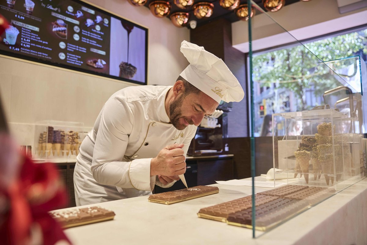 Atrevia's tweet photo. 🍫 Barcelona estrena una nueva forma de vivir el chocolate.
 
#Lindt inaugura en Rambla Catalunya 85 su nueva boutique en Barcelona: un espacio de 170 m², más de 60 m² de terraza y el primer Chocolate Bar de estas características de la marca en #España.
 
Gofres, churros, cafés, helados, chocolate en todas sus formas y, por supuesto, las icónicas creaciones de Lindt. Una propuesta que convierte la experiencia de compra en un auténtico punto de encuentro alrededor del chocolate.
 
La nueva tienda también refuerza su oferta de retail con una gran isla Pick & Mix que reúne las múltiples variedades LINDOR, ediciones limitadas, referencias exclusivas y las últimas innovaciones de la marca: Lindt Dubai Style Chocolate y Lindt Tokyo Style Chocolate
 
Con esta apertura, Lindt da un paso más en #Barcelona y refuerza su apuesta por crear experiencias de marca que van mucho más allá del producto. ✨