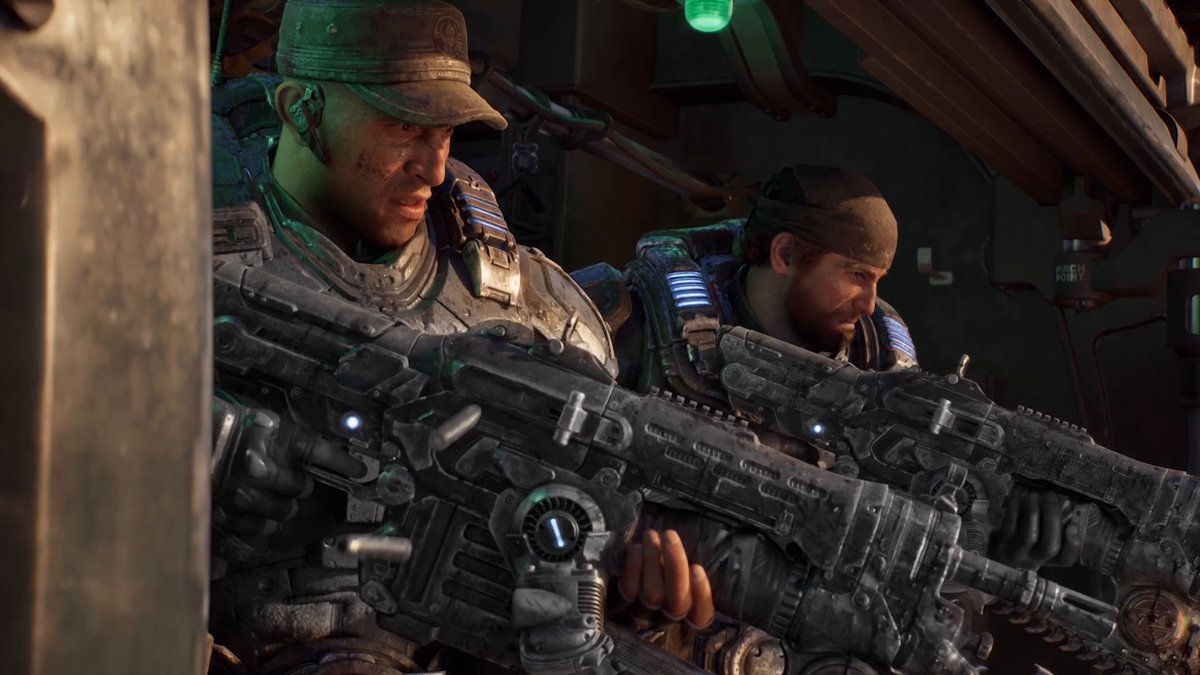 A cinematic screenshot from the video game Gears of War showing two soldiers in heavy futuristic armor holding large assault rifles while taking cover in a dimly lit industrial setting.