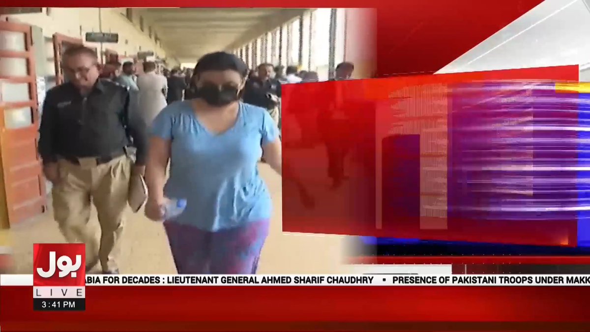 A news broadcast from Bol Live showing two people walking down a hallway, with a news ticker at the bottom referencing Lieutenant General Ahmed Sharif Chaudhry and Pakistani troops.
