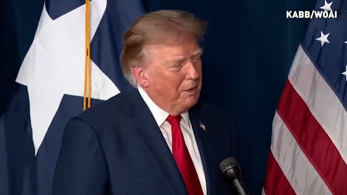 Former US President Donald Trump is shown at a podium with a microphone, wearing a dark suit and red tie, with an American flag and another flag behind him. The image is credited to KABB/WOAI in the top right corner.