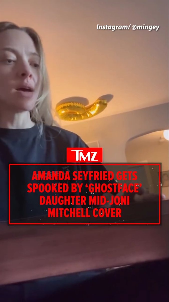 Amanda Seyfried appears startled in an Instagram video (@mingey) while her daughter interrupts her mid-Joni Mitchell cover with a "Ghostface" costume, as the TMZ headline "AMANDA SEYFRIED GETS SPOOKED BY 'GHOSTFACE' DAUGHTER MID-JONI MITCHELL COVER" captures the playful Halloween surprise.