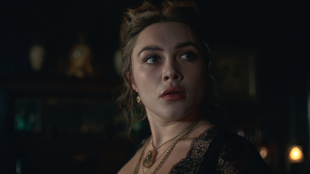 A woman with curly hair, wearing a black lace top and layered gold necklaces, gazes off-camera with a stunned, wide-eyed expression in a dimly lit setting. The image conveys the feeling of being utterly captivated or surprised, fitting the post's theme of someone occupying your thoughts uncontrollably.