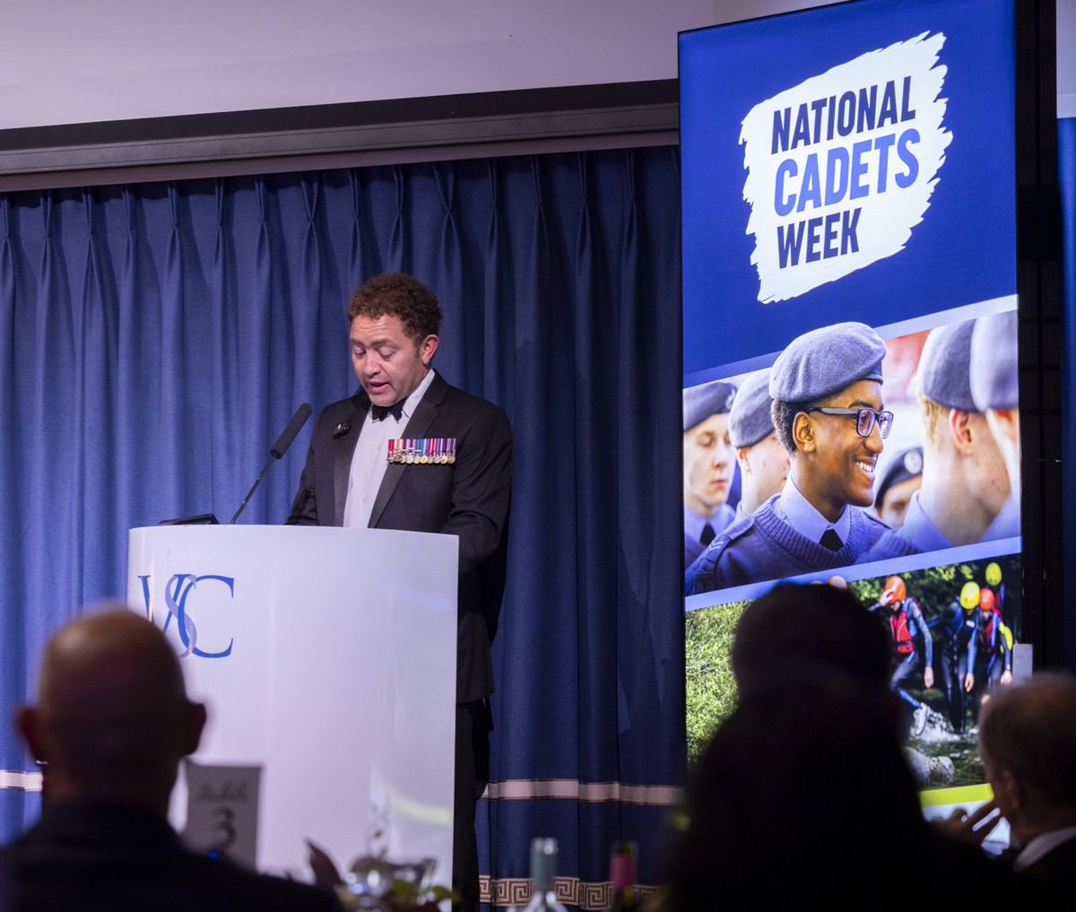 228SqnATC's tweet photo. @CalvinBailey speaking at last night's event to celebrate Cadet Force Adult Volunteers during #NationalCadetsWeek. The face on the poster belongs to none other than our very own Cpl W-J! @aircadets @Kentaircadets https://t.co/qyM8xWGj6l