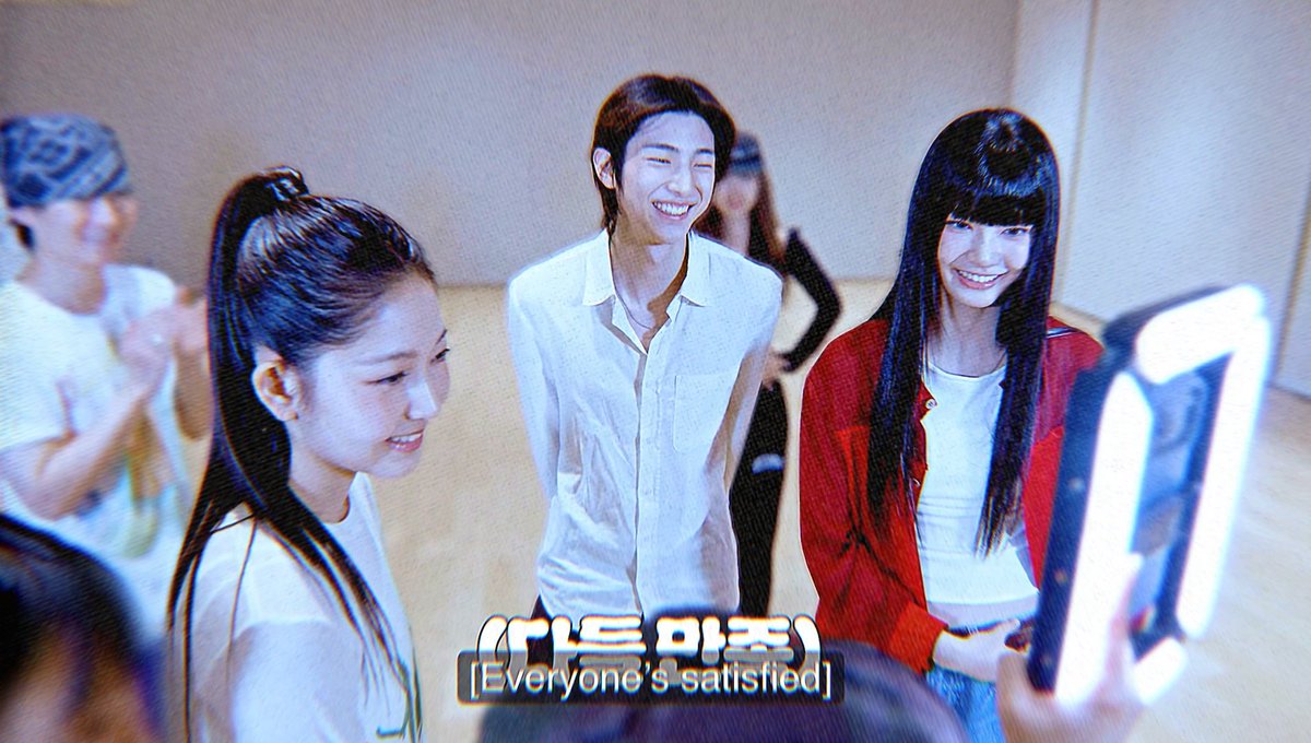 Three young people, including a smiling girl in a red cardigan, a laughing man in a white shirt, and a girl in the foreground, stand together looking at something off-camera; Korean text with the subtitle '[Everyone's satisfied]' appears at the bottom.