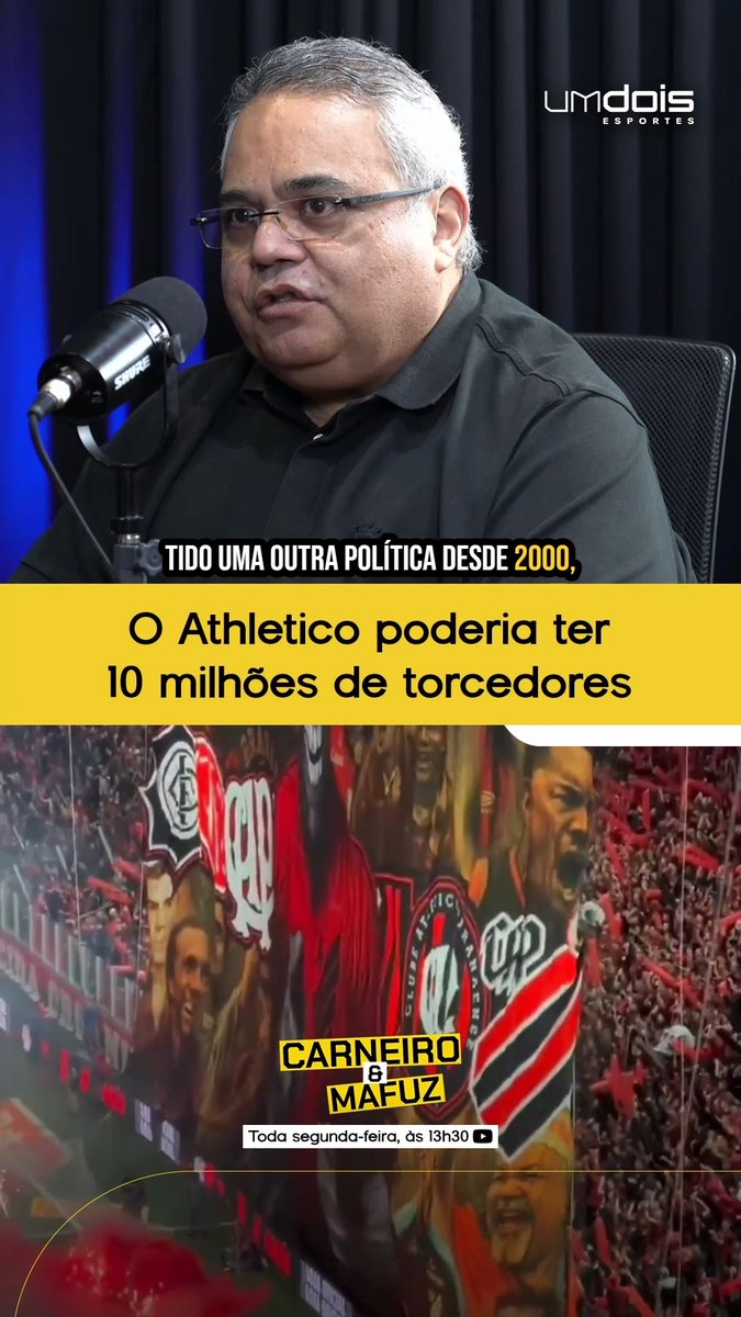 The image shows a man with glasses speaking into a Shure microphone on the "Carneiro é Mafuz" podcast for Um Dois Esportes, with text overlays stating "TIDO UMA OUTRA POLÍTICA DESDE 2000" and "O Athletico poderia ter 10 milhões de torcedores," accompanied by a background of Athletico fans waving flags. The image directly illustrates the podcast discussion about Athletico Paranaense's missed opportunity to significantly expand its fanbase beyond its current ~3.5 million supporters through different strategic decisions since 2000.