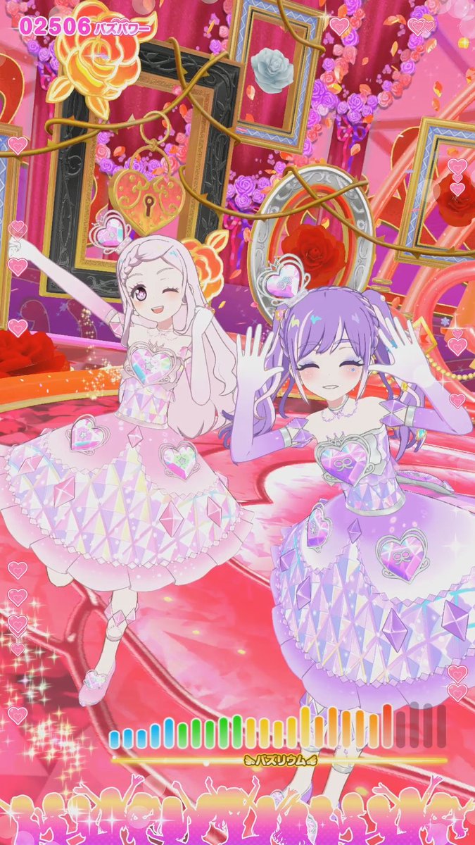 An anime-style game screenshot titled '02506 バズパワー' shows two characters in sparkling pink and purple dresses posing on a stage decorated with roses and picture frames, with a 'ヘレスリウム' progress bar at the bottom.