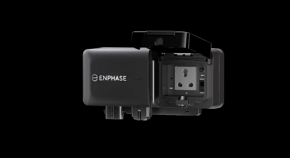 A black Enphase electrical device with its cover opened to reveal a three-prong power outlet and indicator lights, set against a dark background.