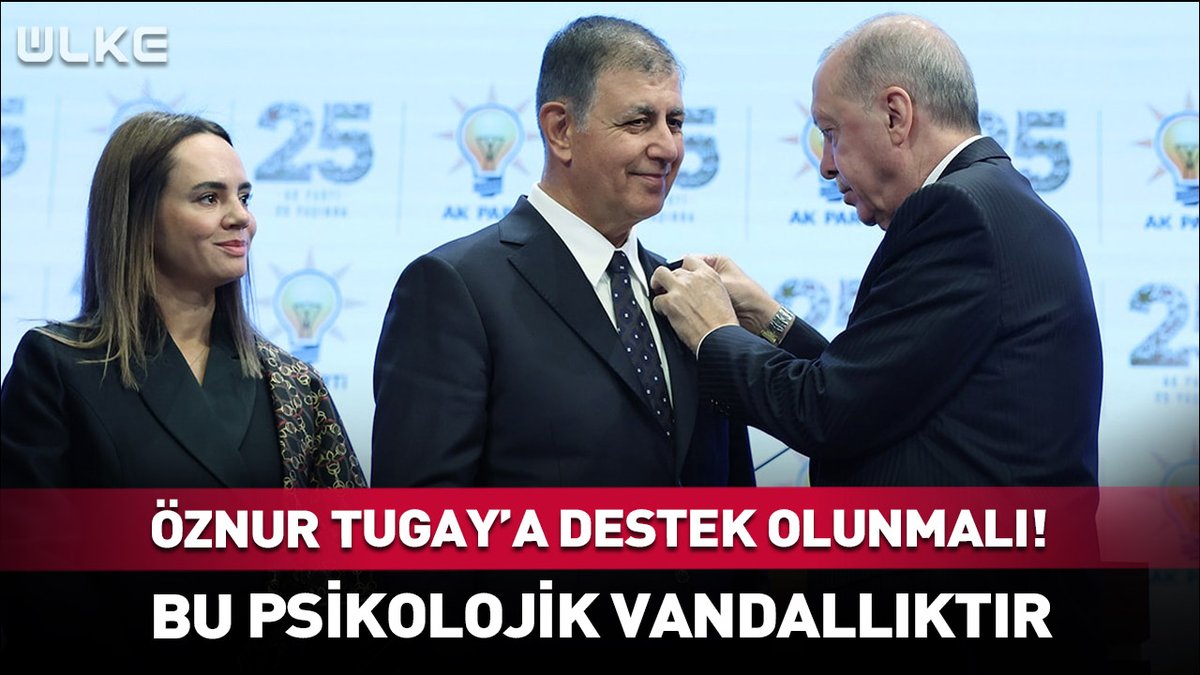 The image shows a ceremony where a man in a suit is pinning a badge or medal onto another man's lapel, while a woman with long hair stands to the left smiling. Turkish text at the bottom reads "ÖZNUR TUGAY'A DESTEK OLUNMALI!" and "BU PSİKOLOJİK VANDALLIKTIR," with a "ULKE" channel logo and "25. YIL" anniversary graphics in the background, suggesting the image is being used to illustrate a news segment calling for support for Öznur Tugay and labeling the situation as psychological vandalism.