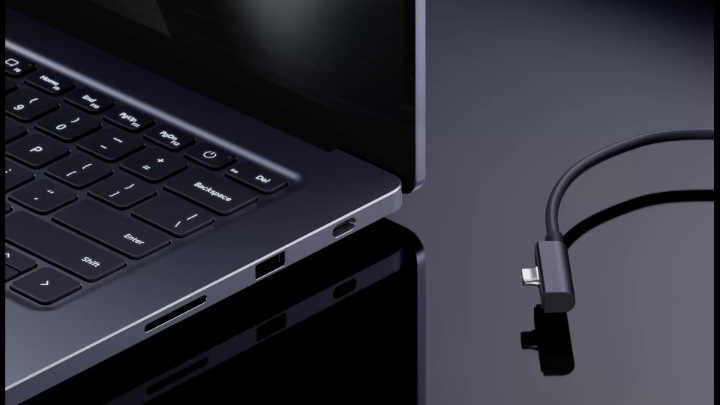 A close-up product image shows the side ports of a dark laptop next to a black USB-C cable connector against a dark background.