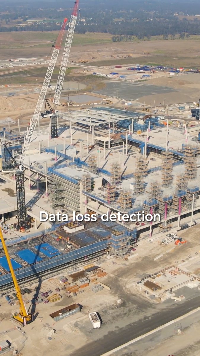 An aerial view of a large construction site with multiple cranes and building foundations, overlaid with the text 'Data loss detection'.