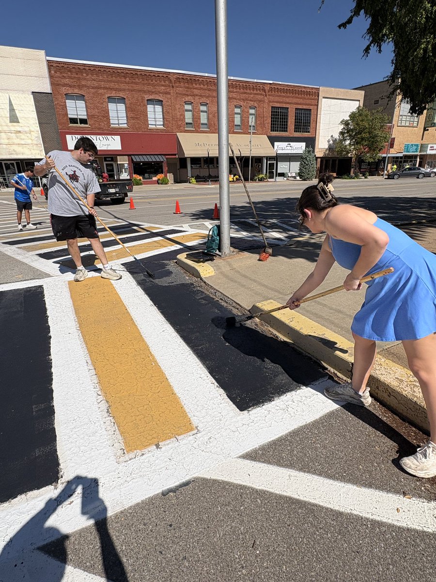 NWOSU's tweet photo. Members of a Ranger Connection class paint a crosswalk in downtown Alva today preparing for both the Alva Goldbug Homecoming celebration on Friday and the #NWOSU  Homecoming on Saturday. https://t.co/ZLiVLMXGCt
