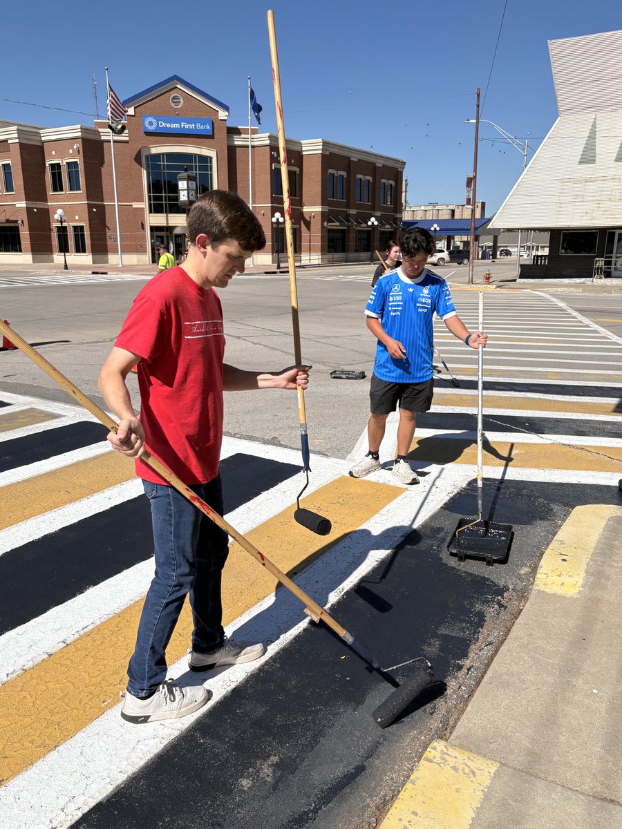 NWOSU's tweet photo. Members of a Ranger Connection class paint a crosswalk in downtown Alva today preparing for both the Alva Goldbug Homecoming celebration on Friday and the #NWOSU  Homecoming on Saturday. https://t.co/ZLiVLMXGCt
