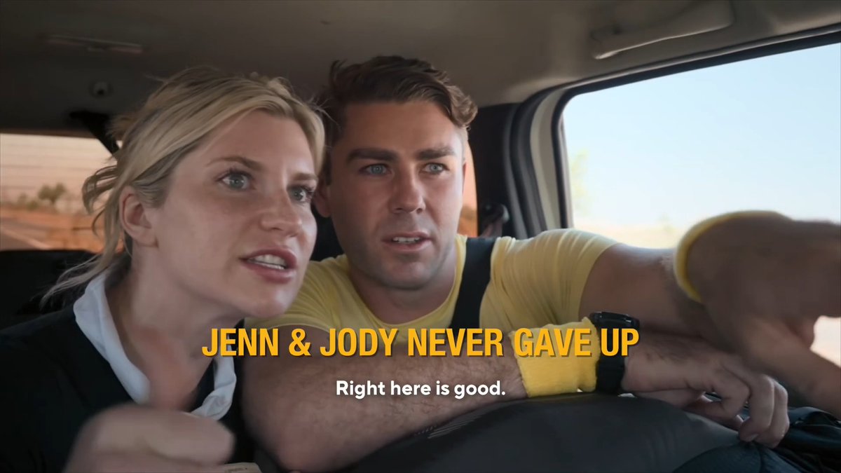 A blonde woman and a man in a yellow shirt sit inside a vehicle looking intently forward; text reads 'JENN & JODY NEVER GAVE UP' and 'Right here is good.'