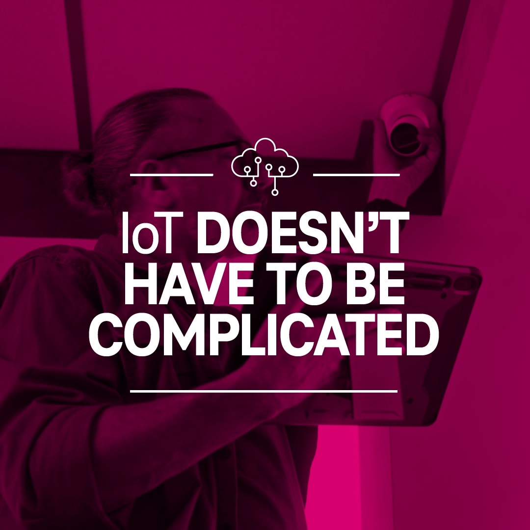 A magenta-toned promotional graphic with the text 'IoT DOESN'T HAVE TO BE COMPLICATED' overlaid on an image of a technician working with equipment.