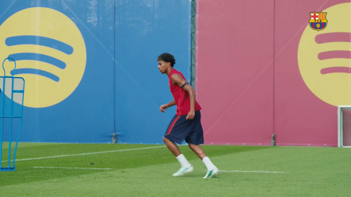 Lamine Yamal jogs during an FC Barcelona training session, with the Spotify and FCB crest logos visible on the backdrop behind him. The image complements the post's reference to his impressive assist to Adeyemi, highlighting the player behind the play.