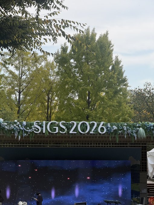 An outdoor event stage with a starry LED screen and "SIGS 2026" displayed in white letters against a floral backdrop.