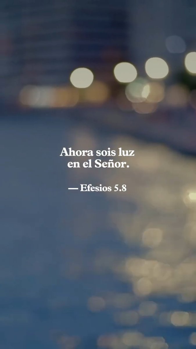 A blurred cityscape image featuring the Spanish Bible verse 'Ahora sois luz en el Señor.' — Efesios 5:8 (Ephesians 5:8).