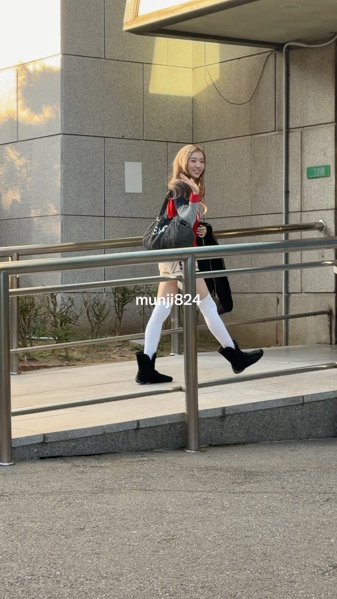 A young woman with long blonde hair poses on outdoor steps wearing a gray sweater, white knee-high socks, black boots, and a backpack, with the text 'munjii824' visible.