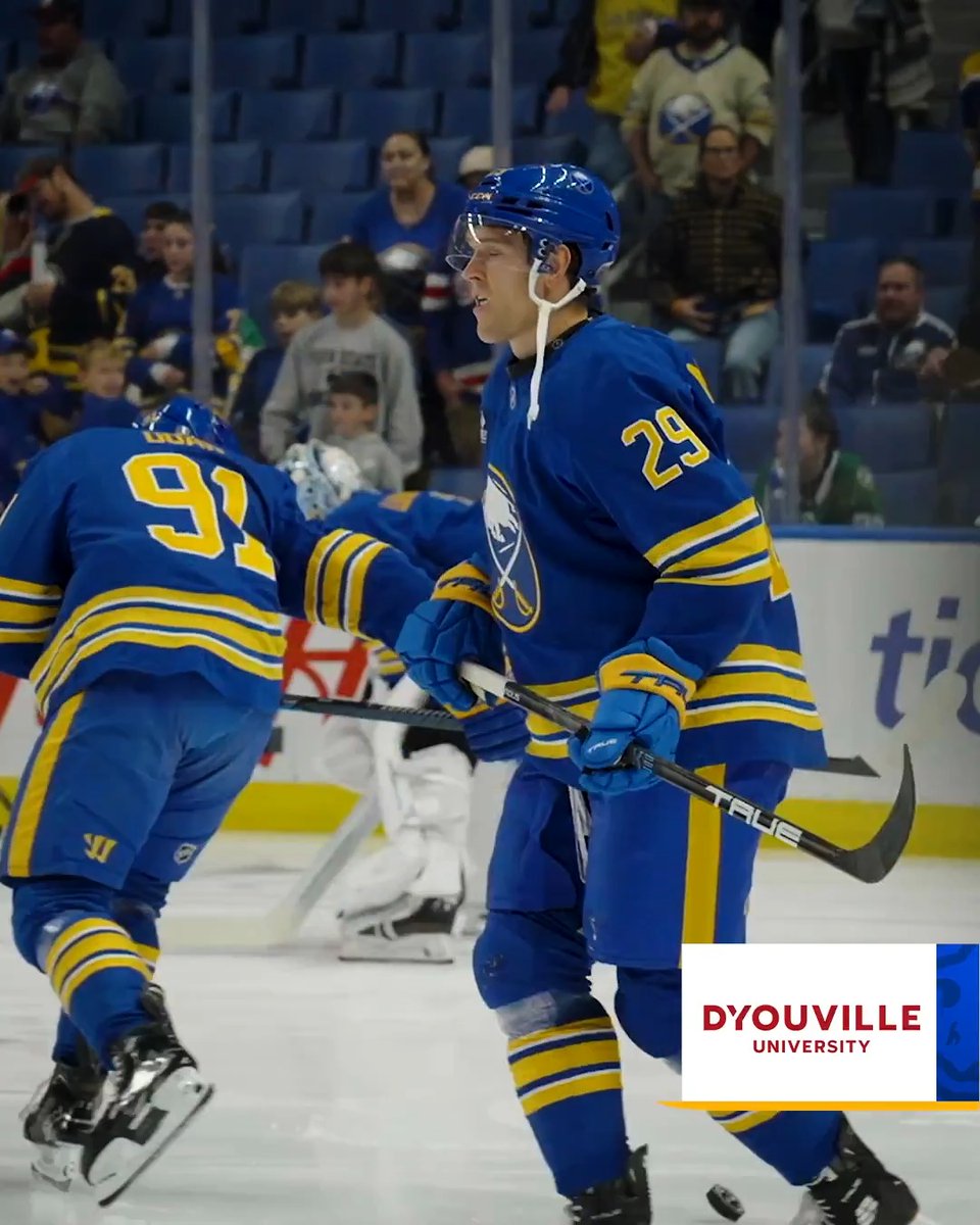 Buffalo Sabres player #29 skates on the ice in the team's blue jersey while teammate #91 appears to be moving away, with a D'Youville University logo visible in the corner of the image, tying into the post's reference to @DYouville.
