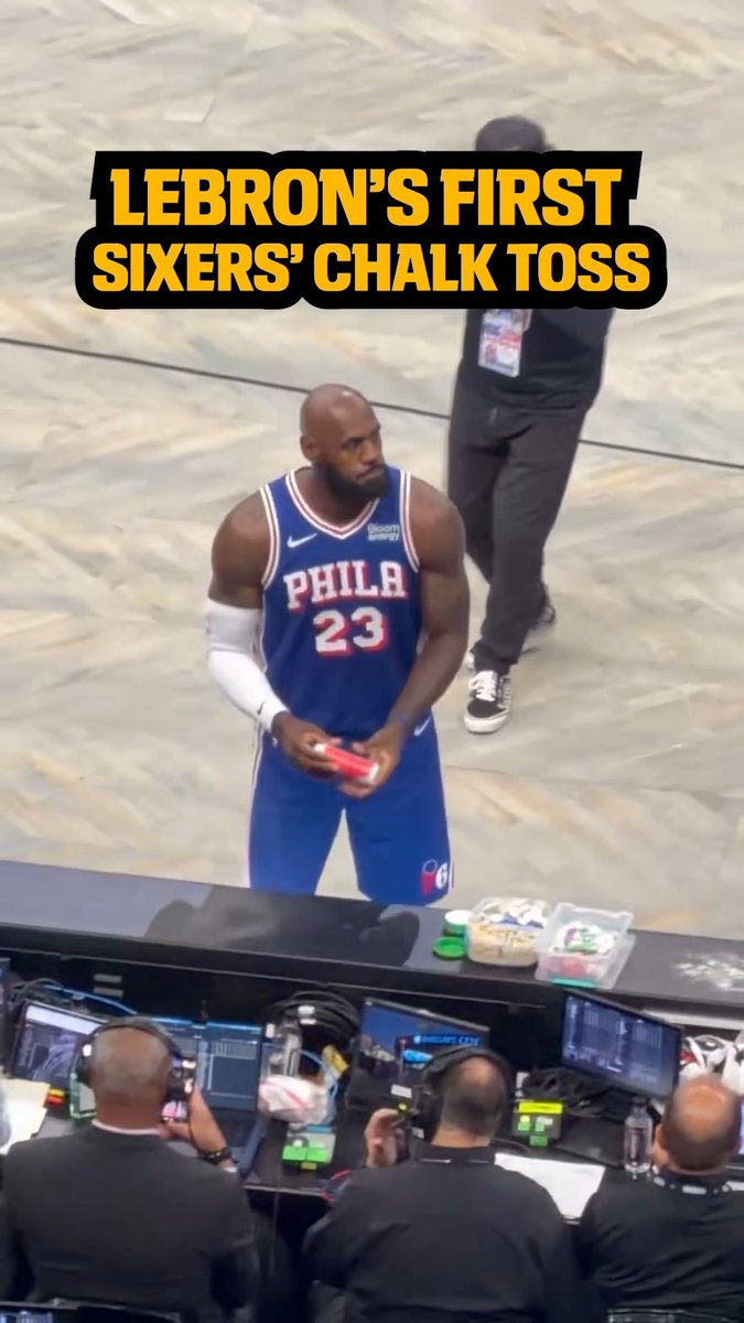 LeBron James, wearing his new "PHILA 23" jersey, stands courtside holding chalk before tossing it into the air, with text overlay reading "LEBRON'S FIRST SIXERS' CHALK TOSS." The image captures a memorable moment of LeBron embracing his new Philadelphia identity—something fans down under might be eagerly watching over their morning "brekkie."