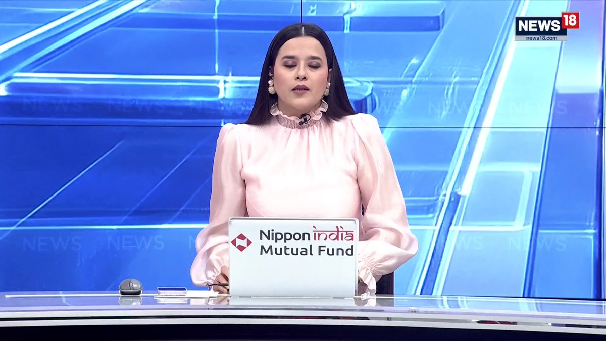 A News18 anchor delivers a broadcast with a laptop displaying "Nippon India Mutual Fund" branding, contextualizing the breaking news segment about the Starlink dispute between Elon Musk and Indian authorities over security concerns regarding satellite internet.