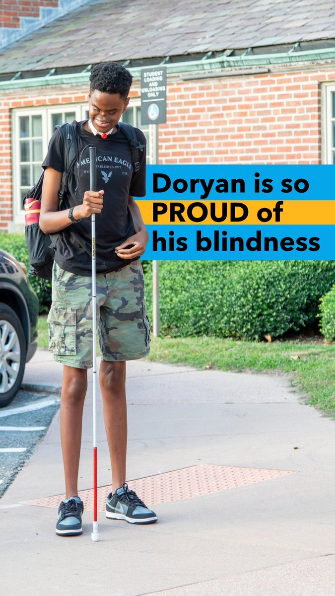A smiling young boy with a white cane and backpack stands on a sidewalk in front of a brick building, with text overlay reading 'Doryan is so PROUD of his blindness.'