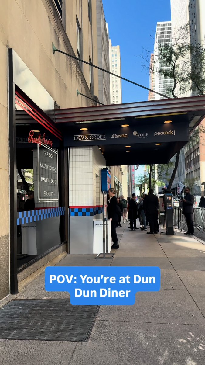 The image shows the exterior of a branded "Brooklyn Diner" turned "Law & Order Dun Dun Diner" pop-up in midtown Manhattan, featuring signage for "Eggs-A-Benny," "Katie's Blue Cheese," "Maccicka Baker," and "Scooter's," along with logos for the show, NBC, Wolf Entertainment, and Peacock. It connects to the post by promoting the limited-time fandom experience tied to *Law & Order* and its Thursday NBC/Peacock airing.