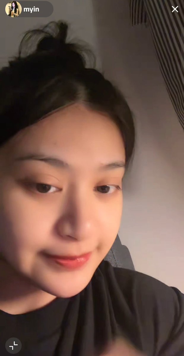A selfie video screenshot of a young woman with dark hair tied up, from a user profile labeled "myin".