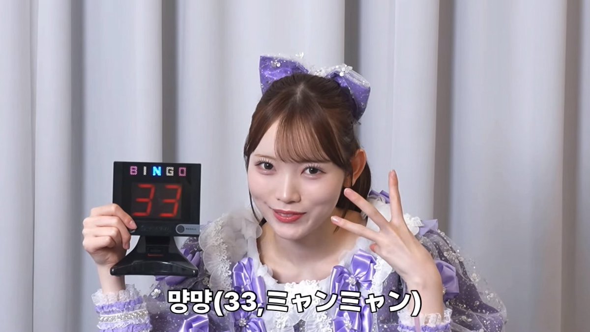 A young woman in a purple idol outfit holding a digital BINGO display showing "33" and making a peace sign, with Korean/Japanese text "망망(33,ミャンミャン)" at the bottom.