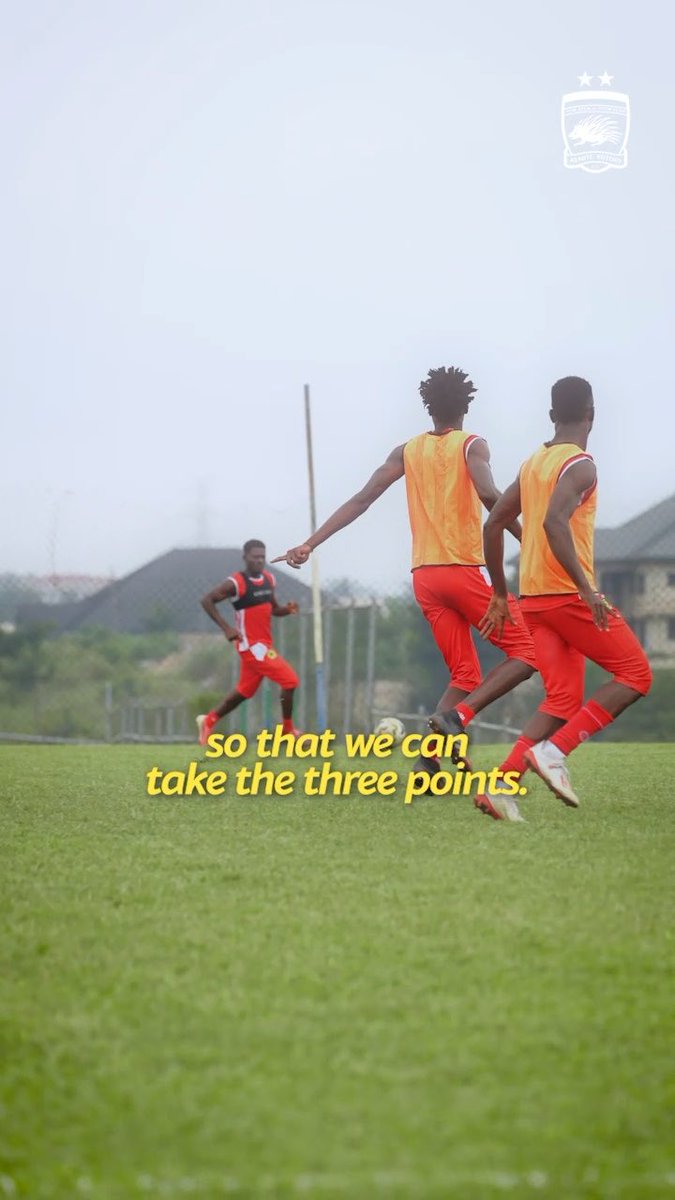Soccer players in orange training pinnies and red uniforms practice on a grassy field, with a caption reading "so that we can take the three points." The image relates to the post by depicting Asante Kotoko's training session focused on discipline and structure ahead of a match, as emphasized by Hamza Obeng.