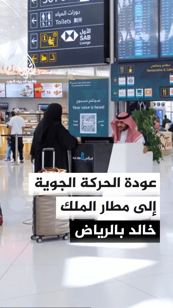 A woman wearing a black abaya pulls a suitcase through what appears to be King Khalid Airport in Riyadh, with Arabic text overlay stating "عودة الحركة الجوية إلى مطار الملك خالد بالرياض" (Return of air traffic to King Khalid Airport in Riyadh), illustrating the post's announcement that the Saudi General Authority of Civil Aviation has resumed normal operations following the attacks.