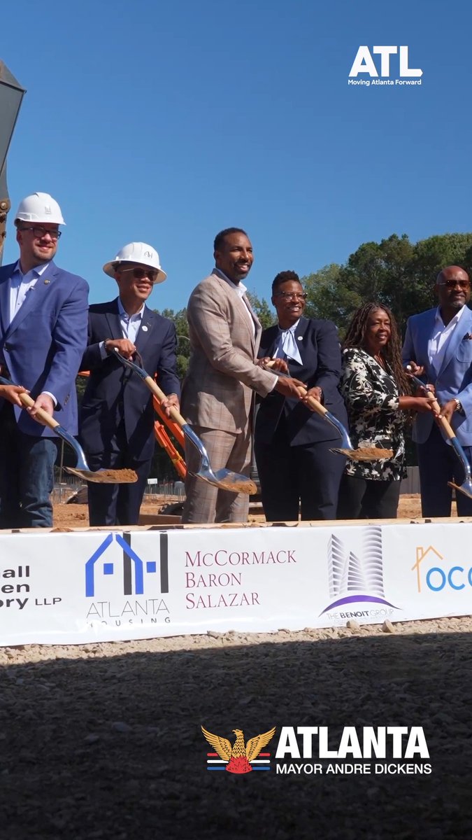 Six people in business attire and hard hats pose with shovels at a groundbreaking ceremony for 'McCormack Baron Salazar' and 'Atlanta Housing', branded with 'ATL Moving Atlanta Forward' and 'ATLANTA MAYOR ANDRE DICKENS'.