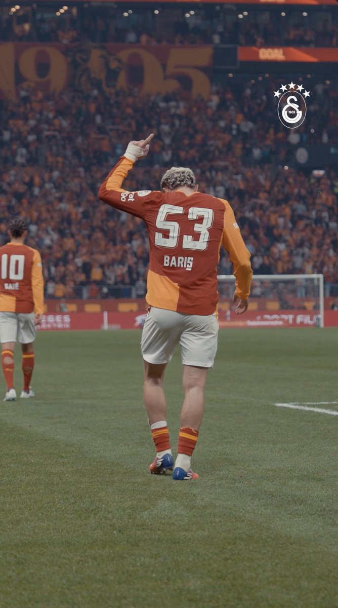 A Galatasaray player wearing jersey #53 with "BARIŞ" on the back raises his hand in celebration on the pitch, with "1905" and the Galatasaray logo visible in the stadium background, capturing the moment after his decisive goal sealed the win.