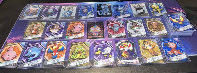 A collection of holographic Pokémon trading cards displayed in protective sleeves, arranged neatly on a gaming mat.