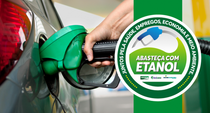 A hand fills a car with green ethanol fuel at a pump, alongside a circular badge reading "ABASTECA COM ETANOL — JUNTOS PELA SAÚDE, EMPREGOS, ECONOMIA E MEIO AMBIENTE," promoting Brazilian ethanol consumption in connection with U.S. trade pressure on the sector.