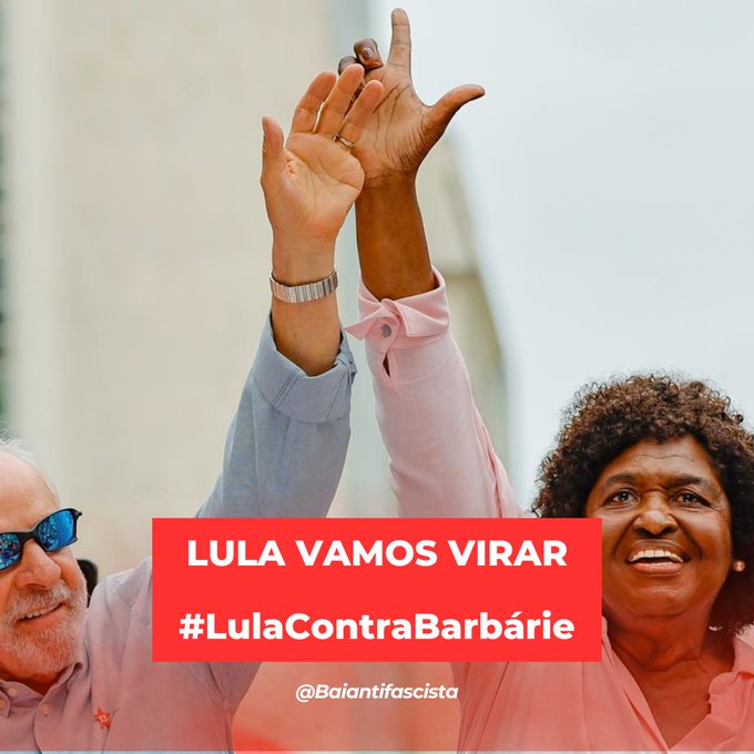 Lula and a woman raise their hands together in a celebratory pose, with the campaign text 'LULA VAMOS VIRAR #LulaContraBarbárie' overlaid on the image.