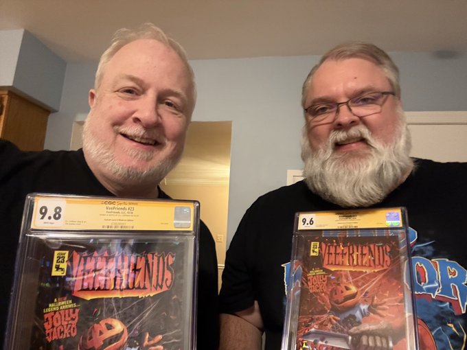 Two smiling men proudly display CGC-graded Valiant Comics issues, with the left man holding 'Ninjak' (graded 9.8) and the right man holding an issue featuring 'Jolly Jacko' (graded 9.6).