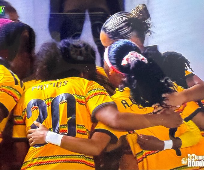 Female soccer players in yellow and red patterned jerseys celebrating together, with 'FRITUS' and #30 visible, marked as a Premiere Honk moment.