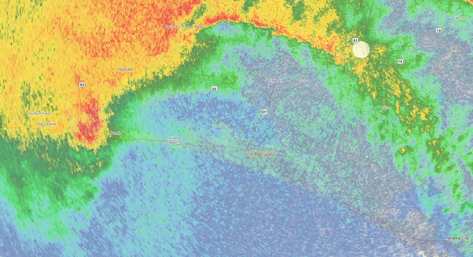 A weather radar map shows intense storm cells with red and orange precipitation patterns sweeping across a region with highways and city labels visible.
