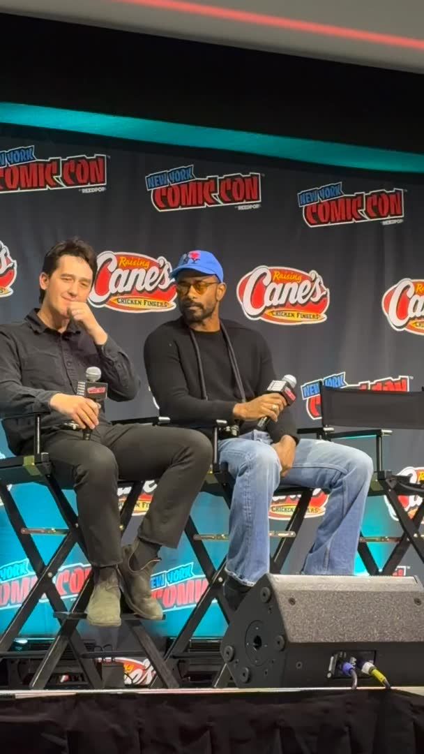 Two men sit on director chairs at a New York Comic Con panel with "Raising Cane's" and "NYCC Reeds" banners behind them, holding microphones during what appears to be a moderated discussion. The scene aligns with the post's mention of Lakeith Stanfield being featured at NYCC, likely as part of a Blumhouse-related discussion.