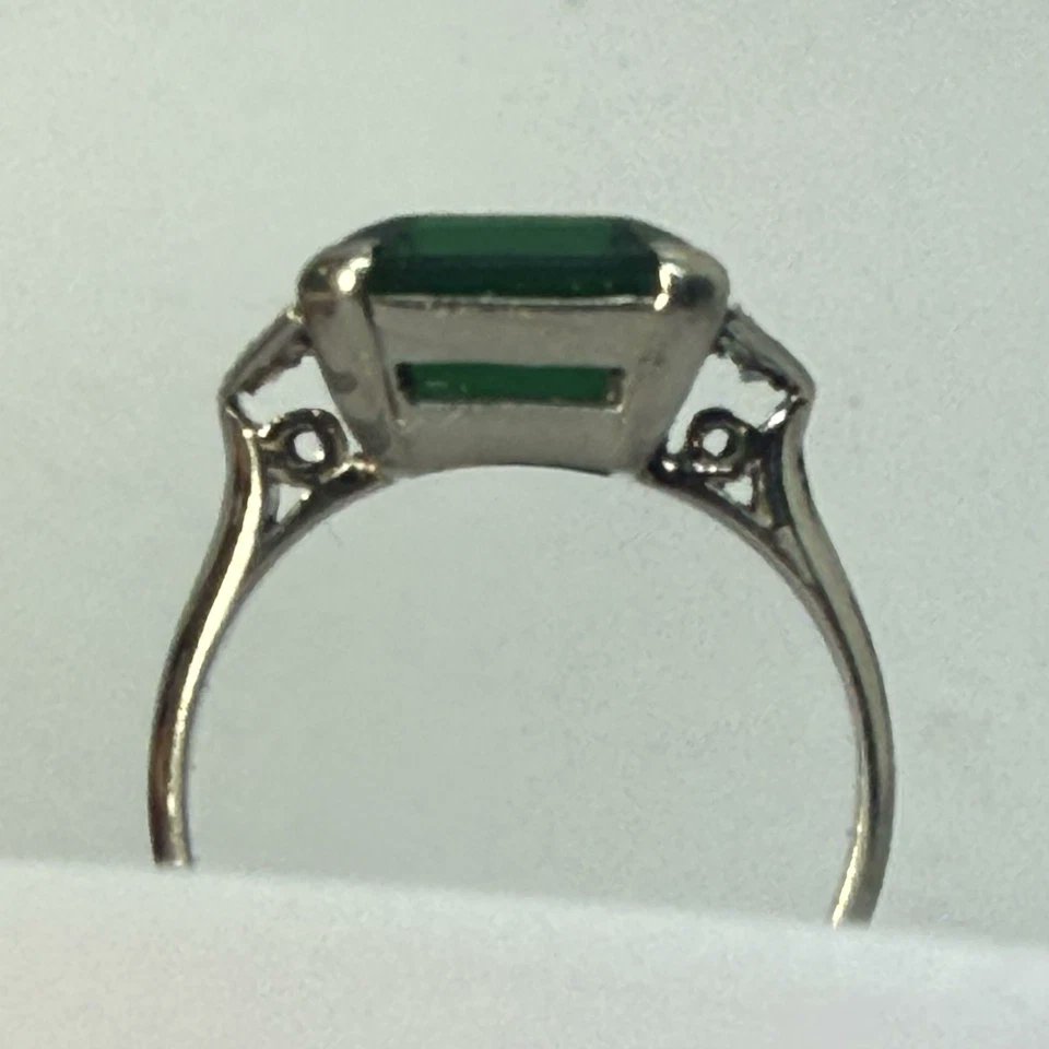Nobel_Antiques's tweet photo. -Stunning Antique American Art Deco Ring- 
Handcrafted in white gold with a striking emerald-cut laboratory made green stone and six natural diamonds.
Regarding the use of synthetic stones in Art Deco period:
During the Art Deco era of the 1920s and 1930s, the use of synthetic gemstones in jewelry was not inherently intended to deceive consumers with imitation or “fake” stones. Rather, it reflected the emergence of groundbreaking laboratory technology that, for the first time in history, made vibrant colored gemstones more widely available and affordable. Synthetic sapphires, rubies, spinels, and other lab-created stones became popular because they offered jewelers exciting new design possibilities at a time when bold geometric patterns and vivid color contrasts defined the Art Deco aesthetic. These stones were often viewed as modern scientific achievements and allowed designers to create striking jewelry that might otherwise have been prohibitively expensive. While proper representation and disclosure still mattered, the presence of synthetic stones in many period pieces should be understood within the historical context of innovation and evolving jewelry manufacturing rather than automatically assuming an intent to mislead
#ArtDeco #VintageJewelry #AntiqueJewelry #EstateJewelry #WhiteGold #DiamondRing #DecoStyle #VintageRing